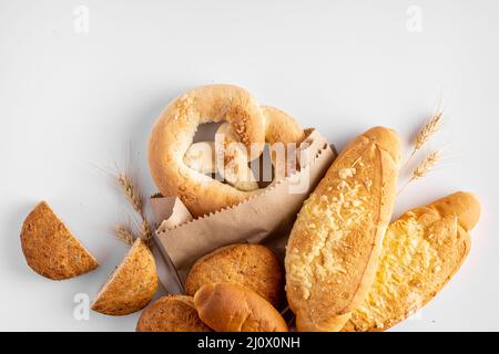 Frisch gebackene verschiedene Backwaren mit Weizen auf hellgrauem Hintergrund Stockfoto