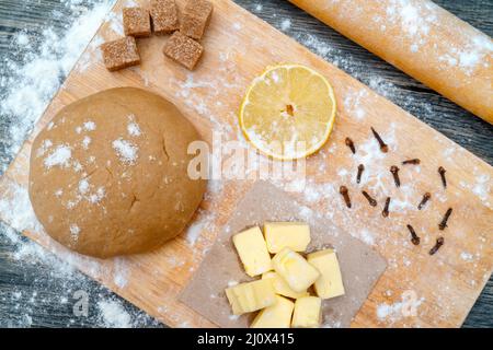 Plätzchenteig. Auf dem Küchentisch. Zutaten - Butter, Zitrone, Mehl, Zucker, Nelken. Stockfoto