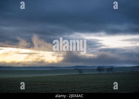 Abendlandschaft - Himmel mit Wolken über Wiesen und Wald. Stockfoto