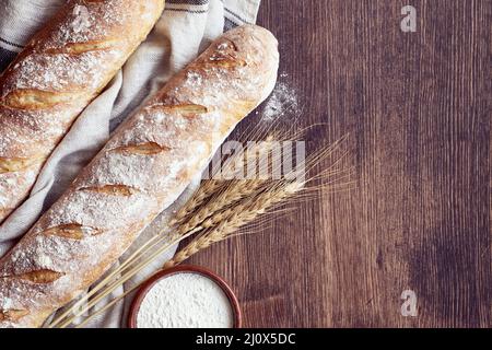 Frisch gebackenes hausgemachtes knuspriges Brot Baguette. Zwei Laibe auf Leinentuch Stockfoto