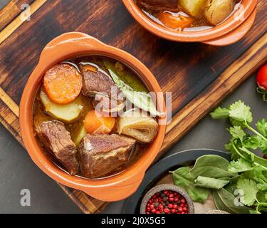 Gulasch mit großen Stücken von Rindfleisch und Gemüse. Burgundisches Fleisch. Langsam einkochen, Kochen in zwei Topf Stockfoto