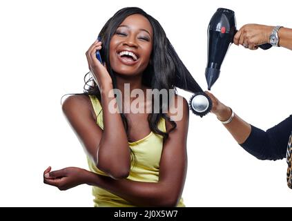 Shes wird danach fabelhaft aussehen. Studioaufnahme einer attraktiven jungen Frau, die ihre Haare blasen muss. Stockfoto