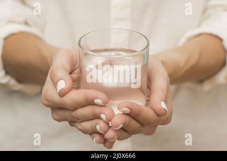 Frau mit mit Wasser gefülltem Glas. Hochwertiges, schönes Fotokonzept Stockfoto