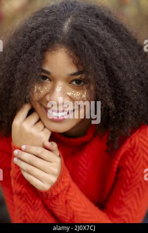 Junge glücklich überglücklich afroamerikanische Frau mit lockigen Haaren halten die Augen geschlossen Lachen und Spaß haben, während im Herbst stehen Stockfoto