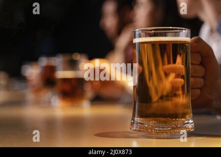 Nahaufnahme Hand hält Bierkrug. Hochwertiges, schönes Fotokonzept Stockfoto