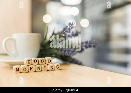 Good Morning kubische Blöcke mit Tasse Kaffee Holzschreibtisch. Hochwertiges, schönes Fotokonzept Stockfoto