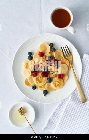 Winzige Pfannkuchen, kleine dünne lustige Krümel, Kindernahrung. Stockfoto