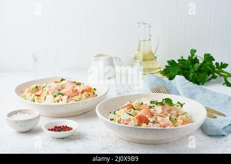 Lachsnudeln, Tagliatelle mit Fisch und cremiger Sauce. Italienisches Abendessen mit Meeresfrüchten Stockfoto