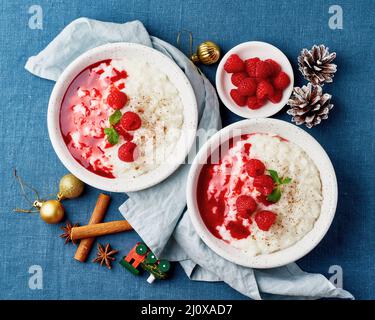 Reispudding. Weihnachtliches Essen. Französischer Milchreis Dessert mit Himbeeren. Dunkler Hintergrund. Stockfoto