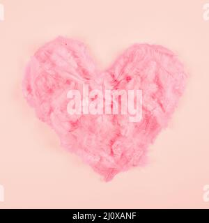 Rosa weiche Feder Herz Form pfirsichfarbenen Hintergrund Stockfoto