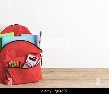 Rote Schultasche mit unverzichtbaren Vorräten. Hochwertige Fotos Stockfoto