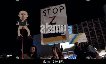 Tel Aviv, Israel. 20. März 2022. Demonstranten halten Schilder auf, während sie sich versammeln, um sich eine Videoansprache des ukrainischen Präsidenten Volodymyr Zelensky vor dem israelischen parlament anzusehen, die am 20. März 2022 auf dem Habima-Platz in Tel Aviv, Israel, ausgestrahlt wurde. Zelenski forderte Israel auf, Sanktionen gegen Russland zu verhängen und der Ukraine zu helfen, indem er sich an Nazi-Deutschland erinnerte und sein Vorgehen mit der aktuellen Situation verglich. Kredit: Eddie Gerald/Alamy Live Nachrichten Stockfoto