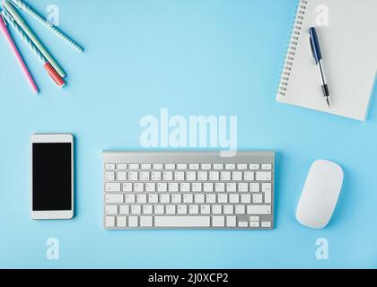 Arbeiten von zu Hause aus, Online-Lernen. Moderner Schreibtisch in hellblauem Blau. Draufsicht. Fernunterricht. Stockfoto