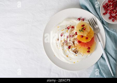 Süßes und gesundes buntes Dessert, gemischter Obstsalat mit Kokosjoghurt. Platz kopieren, Draufsicht Stockfoto