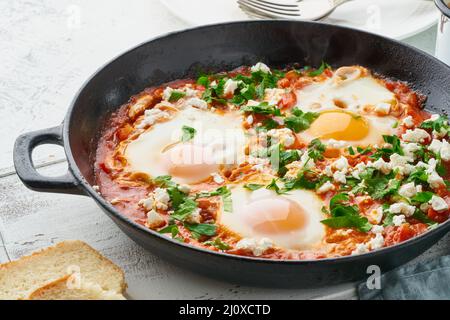 Shakshouka, Eier in Sauce von Tomaten pochiert, Olivenöl. Mediterrane Küche. Stockfoto