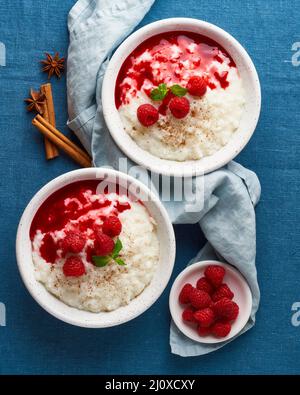 Reispudding. Französisches Milchreisdessert mit Himbeeren, Blaubeeren, Marmelade. Draufsicht, vertikal Stockfoto