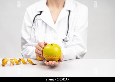 Ernährungsberaterin Frau mit Apfel. Hochwertiges, schönes Fotokonzept Stockfoto