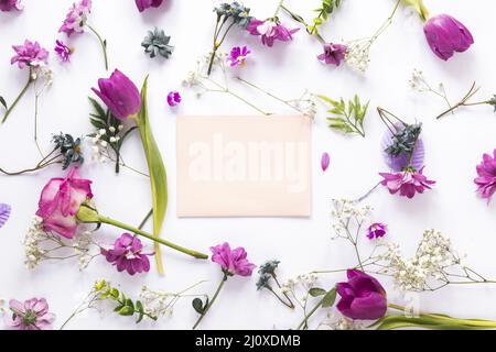 Verschiedene Blumen mit papierweißem Tisch. Hochwertiges, schönes Fotokonzept Stockfoto