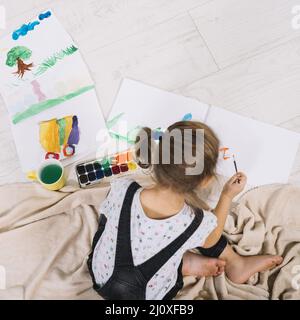 Kleines Mädchen mit Aquarellboden malen. Hochwertiges, schönes Fotokonzept Stockfoto