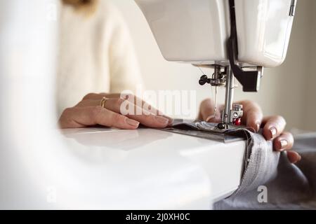 Nahaufnahme der Person mit der Nähmaschine. Hochwertiges, schönes Fotokonzept Stockfoto