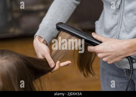 Kleines Mädchen, das ihre Haare aufgerichtet hat. Hochwertige Fotos Stockfoto