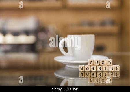 Guten Morgen Holzklötze mit Tasse Kaffee Glas Zähler. Hochwertiges, schönes Fotokonzept Stockfoto