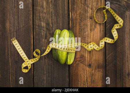 High-Angle-Ansicht frische Gurken Maßband hölzernen Hintergrund. Hochwertiges, schönes Fotokonzept Stockfoto