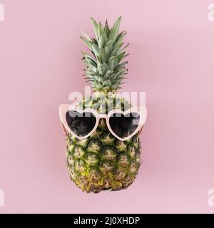 Ananas mit herzförmiger Sonnenbrille von oben Stockfoto