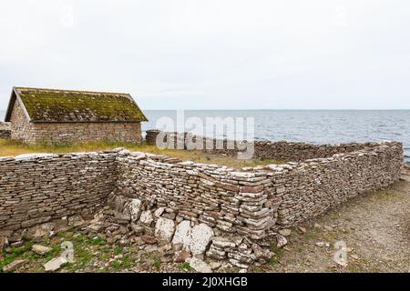 Alten Bootshaus mit Steinmauer am Ufer Stockfoto