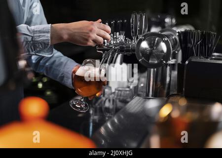 Nahaufnahme von Hand gegossem Bierglas. Hochwertiges, schönes Fotokonzept Stockfoto