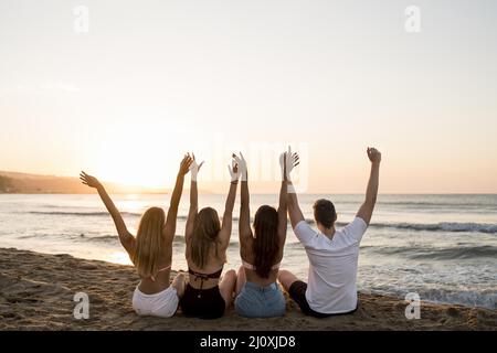 Rückansicht Freunde halten die Hände hoch. Hochwertiges, schönes Fotokonzept Stockfoto