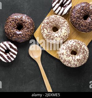 Draufsicht Donuts Schneidebrett mit Holzlöffel. Hochwertiges, schönes Fotokonzept Stockfoto