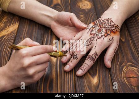 Künstler macht Mehndi Womans Hand. Hochwertiges, schönes Fotokonzept Stockfoto