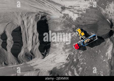 Industriebagger, der Stein, Schotter oder Sand in LKW verladen kann. Luftaufnahme von oben. Stockfoto