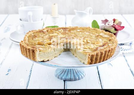 Traditioneller französischer Rhabarber-Torte, der als Nahaufnahme auf einem Kuchenteller auf einem Holzbrett angeboten wird Stockfoto