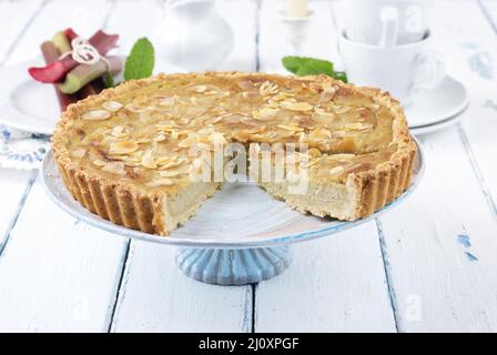 Traditioneller französischer Rhabarber-Torte, der als Nahaufnahme auf einem Kuchenteller auf einem Holzbrett angeboten wird Stockfoto