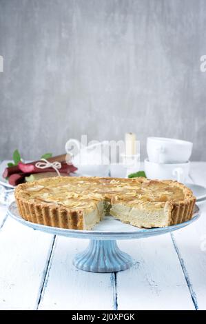 Traditioneller französischer Rhabarber-Torte, der als Nahaufnahme auf einem Kuchenteller auf einem Holzbrett angeboten wird Stockfoto