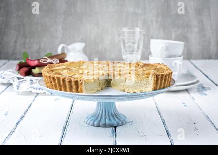 Traditioneller französischer Rhabarber-Torte, der als Nahaufnahme auf einem Kuchenteller auf einem Holzbrett angeboten wird Stockfoto