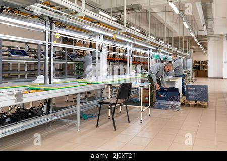 Minsk, Weißrussland - 15. Dezember 2021: Foto einer Anlage zur Montage von Monoblocks für Computer. Arbeiter arbeiten am Förderband Stockfoto