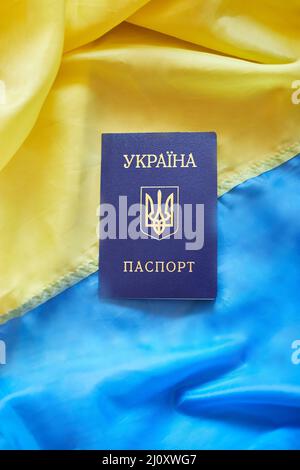 Drei ukrainische nationale Pässe auf der Flagge der Ukraine Stockfoto