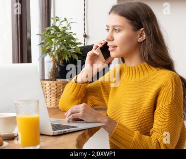 Digitaler Nomade. Junge Unternehmerin im Gespräch auf Handy Stockfoto