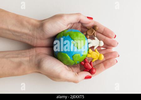 Draufsicht Hände halten Plastilin Globus Menschen. Hochwertige Fotos Stockfoto