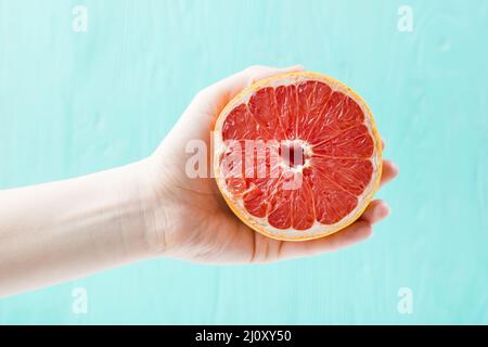 Hand mit frischer Grapefruit. Hochwertige Fotos Stockfoto