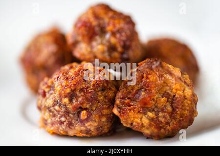 Nahaufnahme gebackenes mikiertes Fleisch mit herzhaftem Käse, auf weißem Teller stapeln. Stockfoto