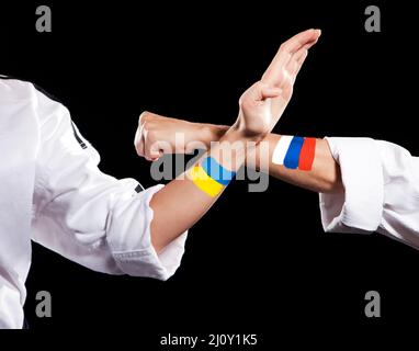 Selbstverteidigung Ukraine und Russland zwei Kampfhände von Vertretern verschiedener Länder. Halten Sie die Hände von zwei kämpfenden Personen fest Stockfoto