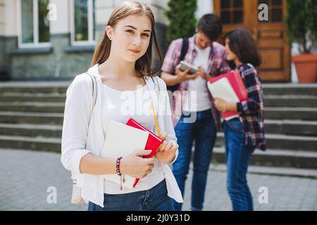Junge Studentin posiert in der Nähe der Universität. Hochwertige Fotos Stockfoto