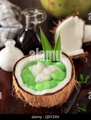 Bubur Sumsum Pandan, Grüner Reisbrei mit Kokosmilch und brauner Zuckersoße, beliebt bei Ramadan Takjil beim Brechen des Fast Buka Puasa Stockfoto