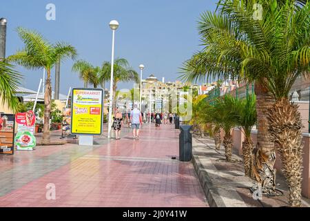 Ein gefliester Bürgersteig, Promenade, die entlang der Küste in Costa Adeje, Linie mit Palmen, um die Touristen zu beschatten Stockfoto