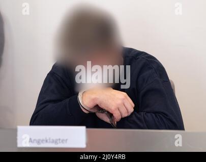 Bad Kreuznach, Deutschland. 21. März 2022. Der Angeklagte sitzt im Dock. Der Mann soll im vergangenen Jahr auf den Mitarbeiter einer Tankstelle in Bad Kreuznach geschossen haben, nachdem er ihm darauf hingewiesen hatte, dass er eine Corona-Maske tragen müsse. Kredit: Boris Roessler/dpa - ACHTUNG: Der Angeklagte wurde durch Befehl des Gerichts/dpa/Alamy Live News pixeliert Stockfoto