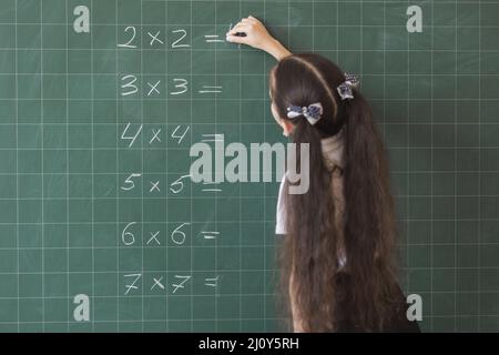 Mädchen macht Berechnungen Tafel. Hochwertige Fotos Stockfoto